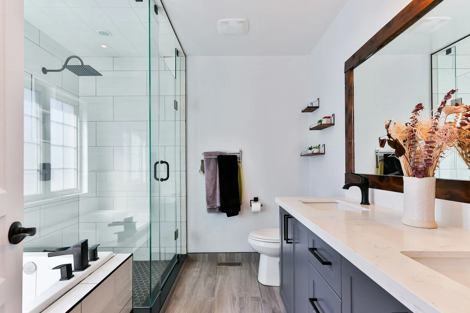 Baño reformado con ducha de obra, mampara de vidrio y mueble con lavabo